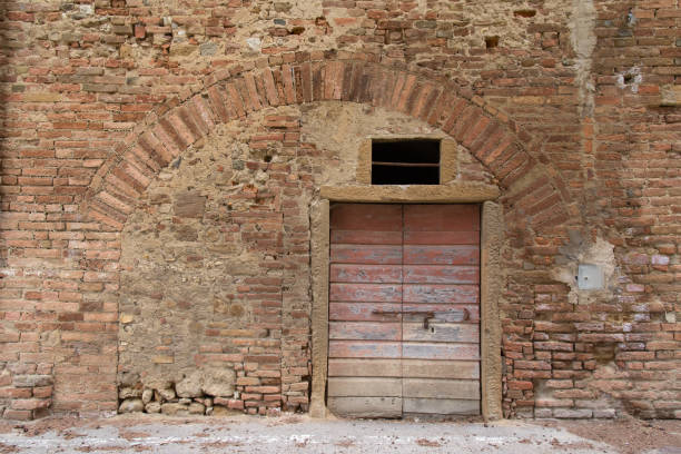 istock Old Tuscan Medieval Wall with Door and old Arch 916975380