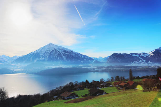 Sigrilwil village with Swiss Alpine mountains and Thun lake Sigrilwil village with Swiss Alpine mountains and Thun lake, Switzerland in winter thun interlaken winter switzerland stock pictures, royalty-free photos & images