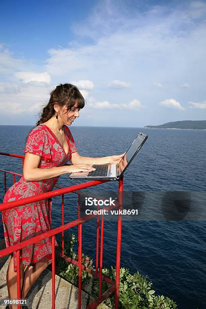 Photo libre de droit de Jeune Fille Avec Ordinateur Portable Sur La Falaise banque d'images et plus d'images libres de droit de Admirer le paysage