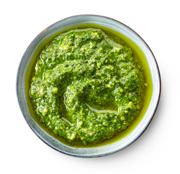 bowl of basil pesto bowl of basil pesto isolated on white background, top view savory sauce stock pictures, royalty-free photos & images
