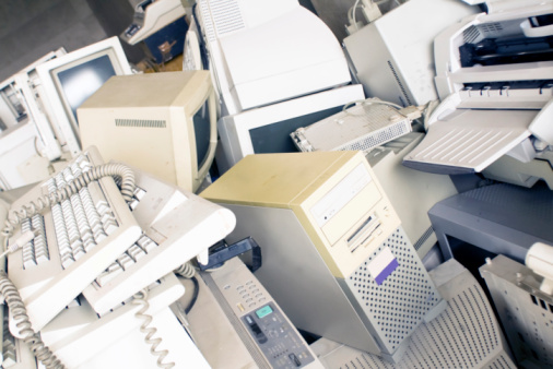 old monitors, computers, copy machines, and other office supplies in the waste