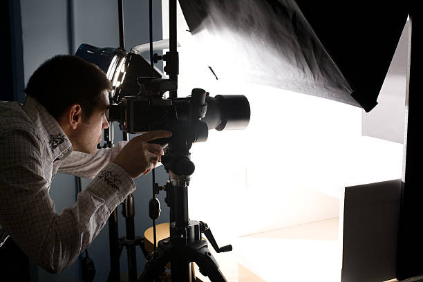 istock Photographer Looking Through Viewfinder Making Adjustments to Camera In Studio 91698451