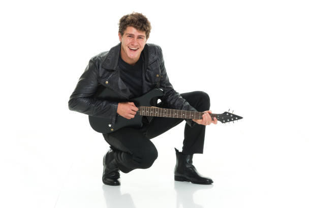 istock Attractive man playing electric guitar crouching 916985546