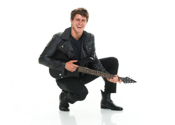 istock Attractive man playing electric guitar crouching 916985572
