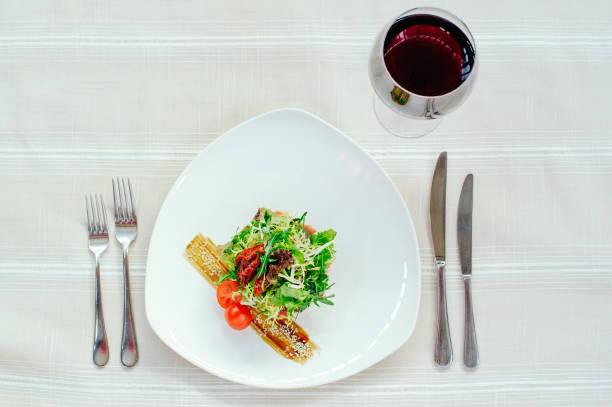 istock delicate exquisite salad Migdal turkey melange in a white plate with wine and table setting on a white tablecloth 916994482