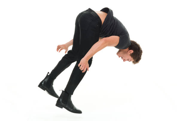 istock Attractive man in all black clothing doing back flips 916994778