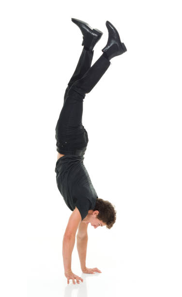 istock Attractive man in all black clothing doing hand stands 916994838