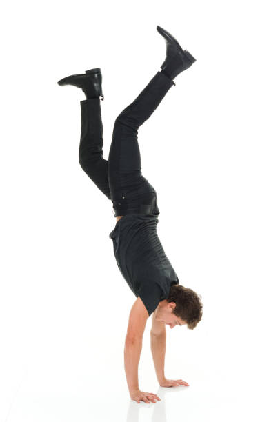 istock Attractive man in all black clothing doing hand stands 916994844