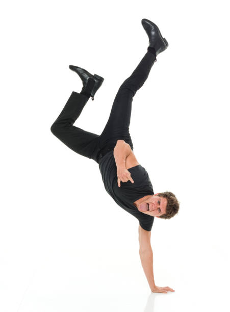 istock Attractive man in all black clothing doing hand stands 916994888
