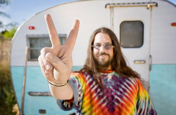 kuvapankkikuvat ja rojaltivapaat kuvat aiheesta mies asuntovaunun edessä tekemässä rauhanmerkkiä - hippie