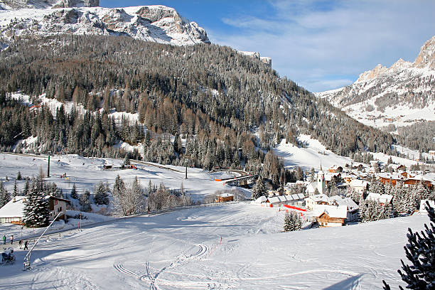 invierno paisaje con alpes dolomíticos, pistas de esquí y pueblo alpino - corvara fotografías e imágenes de stock