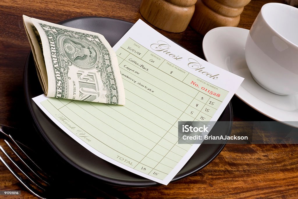 Restaurant guest check with folded dollar bills Guest check and cash in cafe Gratuity Stock Photo