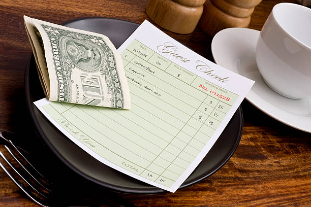 restaurant guest check with folded dollar bills - 貼士 圖片 個照片及圖片檔