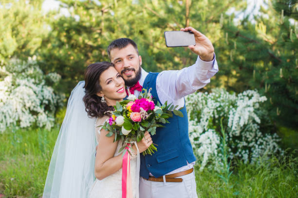 istock Groom make photo with his bride outdoors 917010764