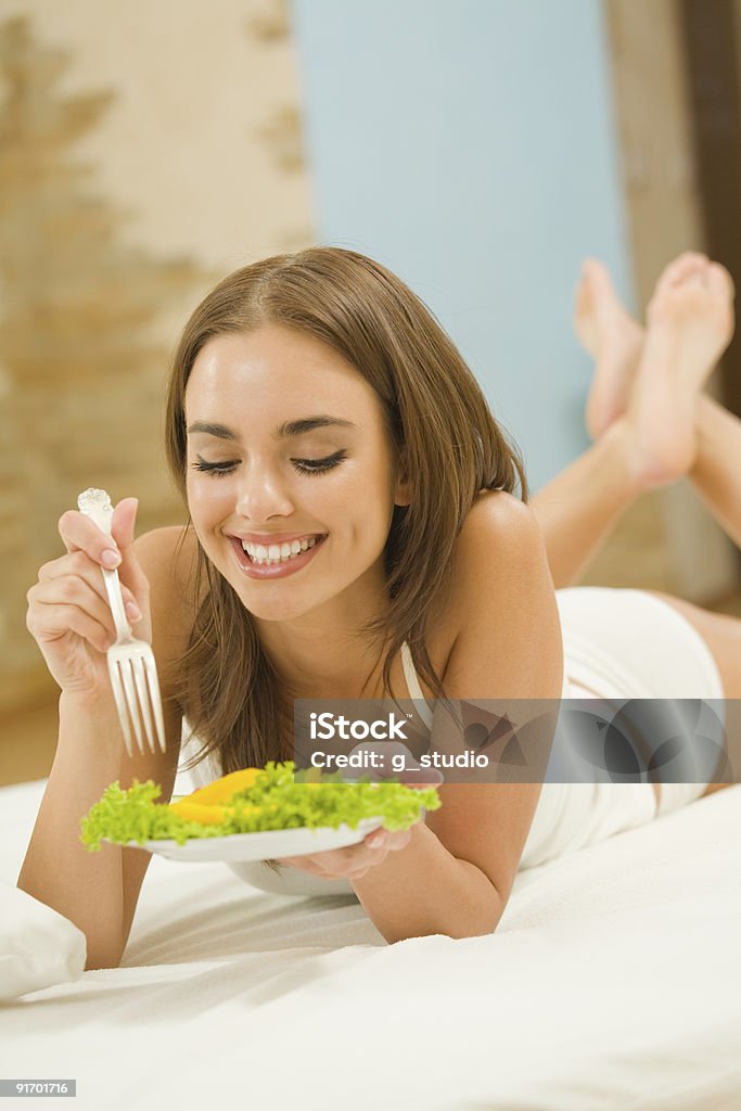 Portrait of young happy woman eating salad at home  Adult Stock Photo