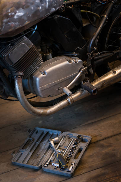 istock Big set tools, which lying near engine of motorcycle in garage 917020598