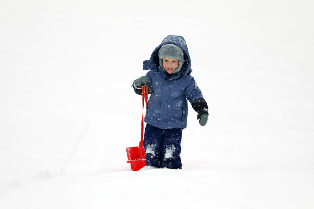 istock Little boy tobogganing and playing with snow 917024148