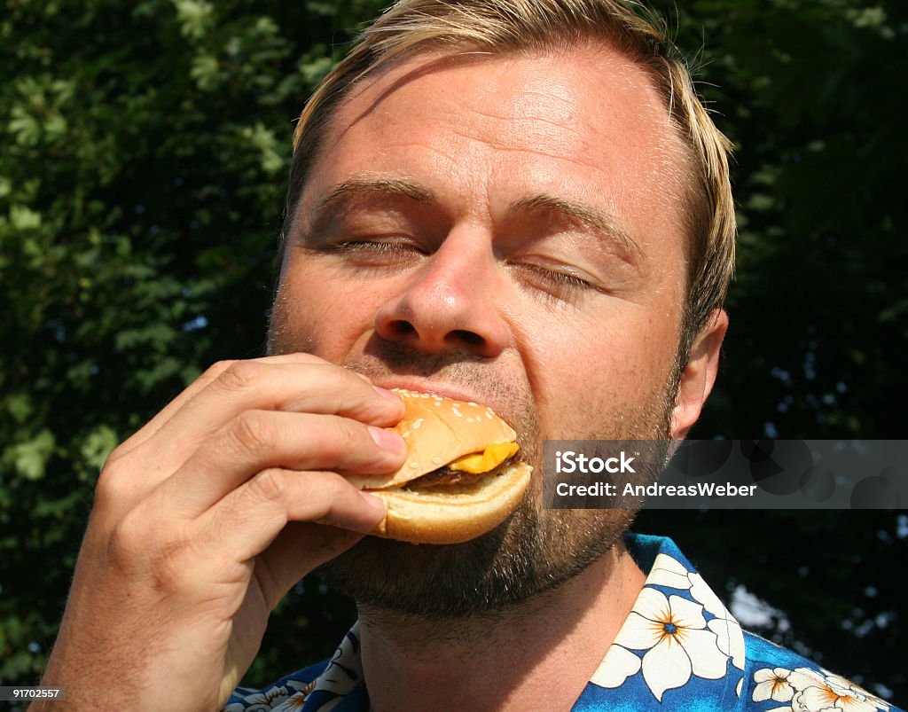 Man eating a cheeseburger  Blond Hair Stock Photo