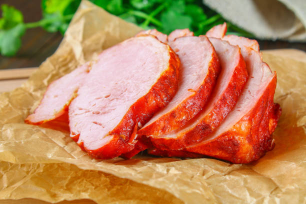 istock Sliced Roast Pork Loin on a brown wooden table with cilantro. 917027232