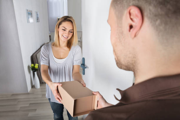 istock Delivery Man Giving Parcel Box To Young Woman 917033758