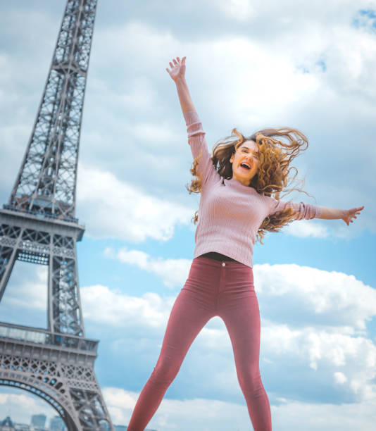 istock Happy young woman jumping against Tour Eiffel 917033980