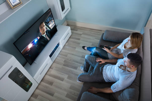 istock Couple On Couch Watching Television 917033988