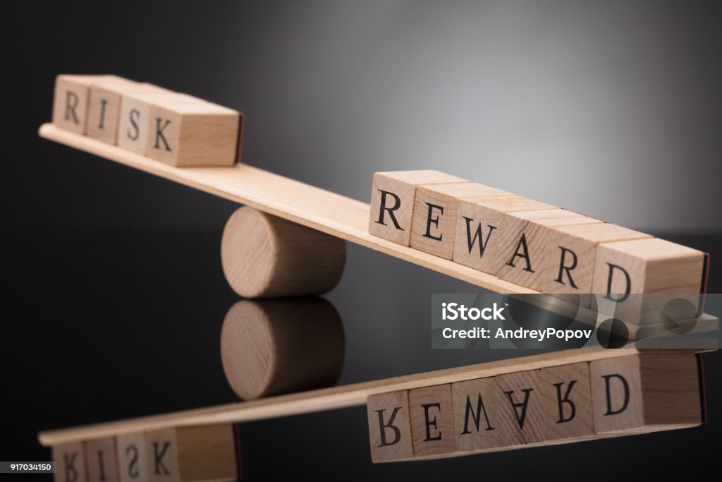 Seesaw Showing Imbalance Between Risk And Reward Close-up Of A Wooden Seesaw Showing Imbalance Between Risk And Reward On Grey Background Risk Stock Photo