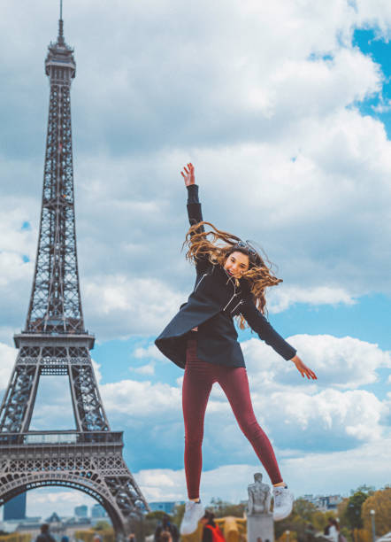 Young girl jumping against Tour Eiffel