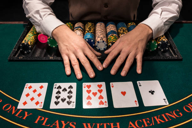 Close up of holdem dealer with playing cards and chips on green table stock photo