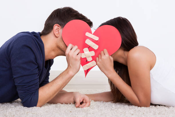 istock Couple Holding Red Paper Heart Fixed With Plaster Bandage 917037296