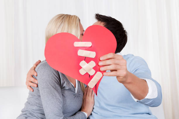 istock Couple Holding Red Paper Heart Fixed With Plaster Bandage 917037304