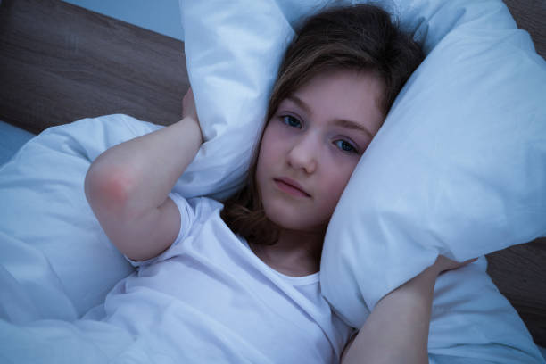 istock Girl Covering Her Ears With Pillow While Sleeping 917037394
