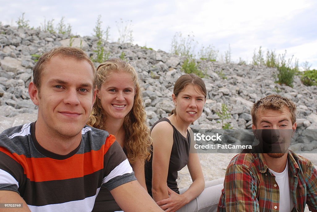 Four Friends Four friends sitting on rocks. 18-19 Years Stock Photo