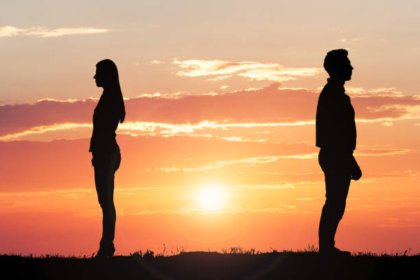 Couple Silhouette Standing Away From Each Other Couple Silhouette Standing Away From Each Other breaking up stock pictures, royalty-free photos & images