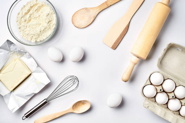 istock Preparation of the dough. Ingredients for the dough - flour, butter, eggs and various tools. On white background. Free space for text . Top view 917040864