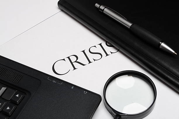 notebook, magnifier and pen with "crisis" word stock photo