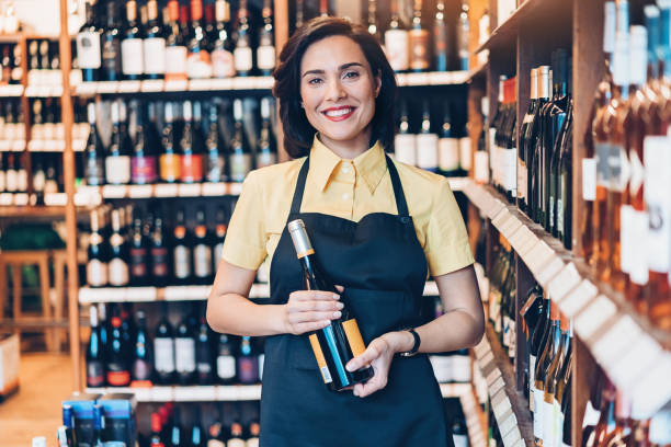 美しい若い女性ワインを販売 - wine cellar liquor store wine rack ストックフォトと画像