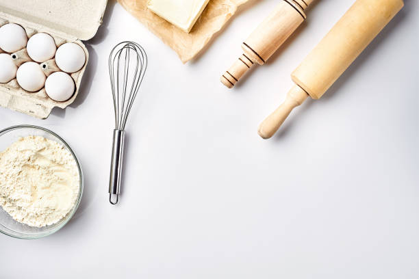 istock Preparation of the dough. Ingredients for the dough - flour, butter, eggs and various tools. On white background. Free space for text . Top view 917043306