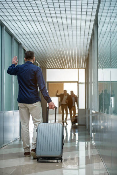 istock Cute guy with baggage is meeting his colleagues 917046538