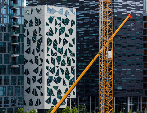 Construction with cranes in Oslo downtown against modern skyline