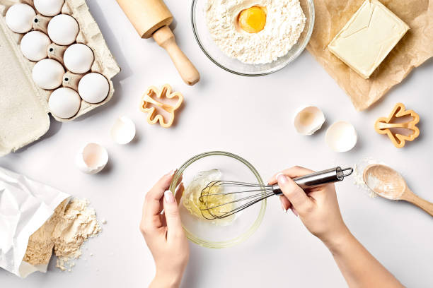 istock Female chef whisking eggs in glass bowl on kitchen table 917046664