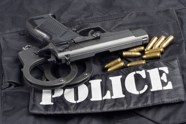 istock Police concept - handgun on black uniform background 917053878