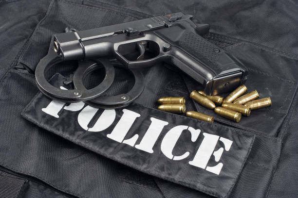 istock Police concept - handgun on black uniform background 917053916
