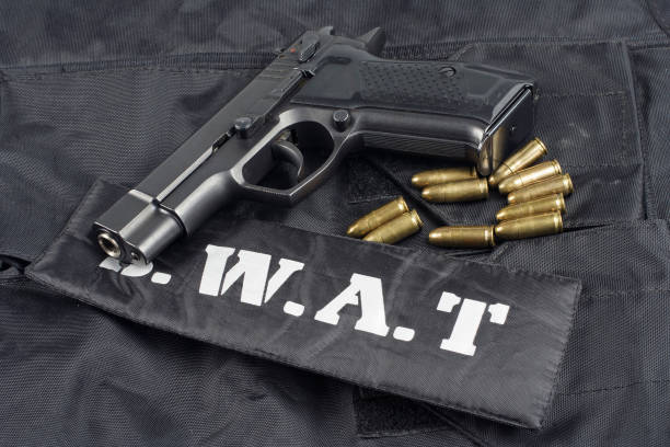 istock SWAT teams concept -handgun on black uniform background 917053972