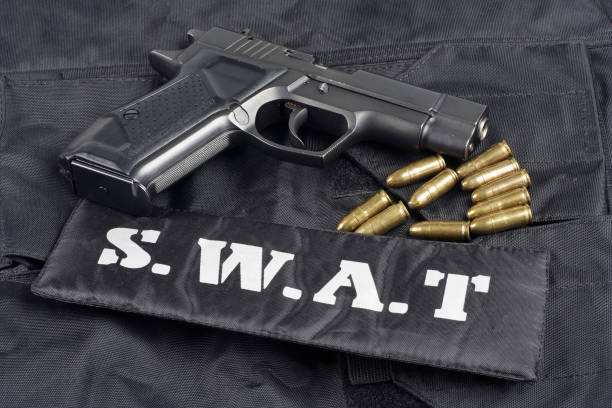 istock SWAT teams concept -handgun on black uniform background 917054024