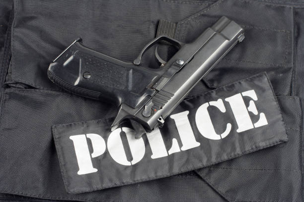 istock Police concept - handgun on black uniform background 917054042