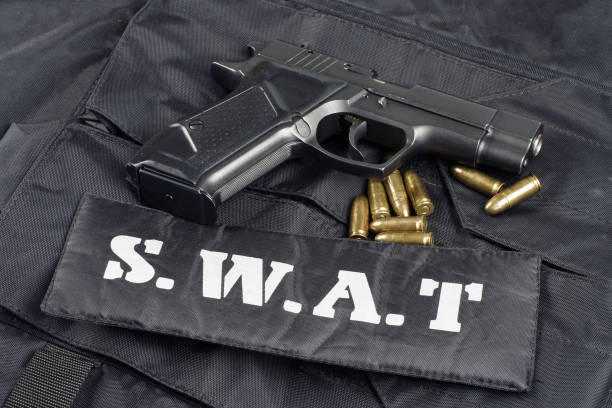 istock SWAT teams concept -handgun on black uniform background 917054066