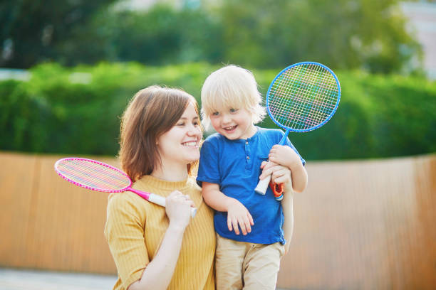 menino jogando badminton com a mãe no recreio - racquette - fotografias e filmes do acervo
