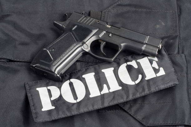 istock Police concept - handgun on black uniform background 917056306