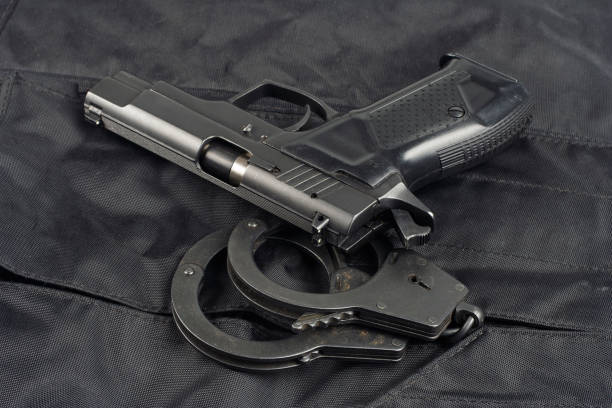 istock Police concept - handgun on black uniform background 917056352